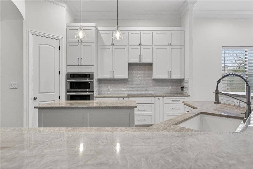 5182 Bayshore Drive, Athens, TX 75752 Kitchen featuring crown molding, white cabinets, light stone counters, double oven, and pendant lighting