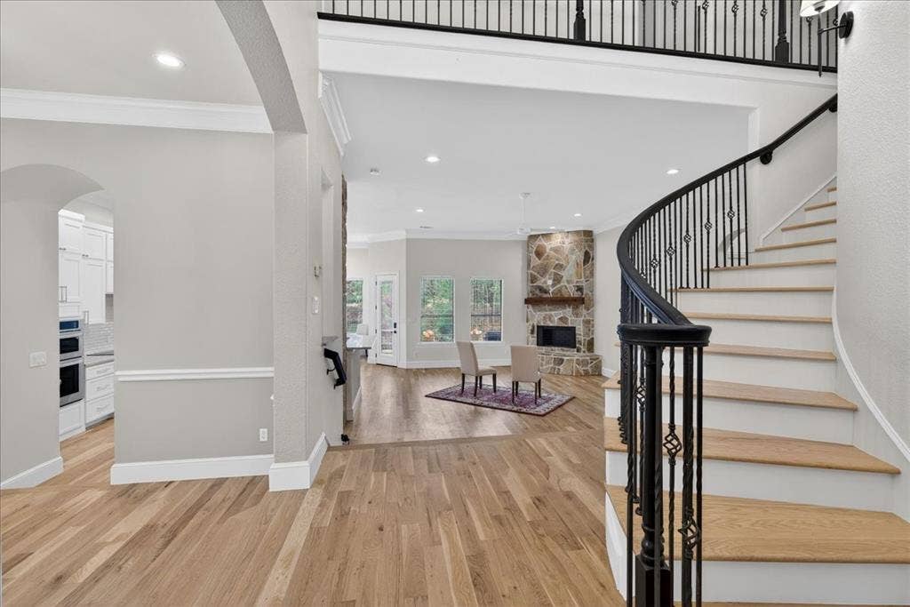 5182 Bayshore Drive, Athens, TX 75752 Foyer entrance with arched walkways, light wood-style floors, crown molding, recessed lighting, and a fireplace
