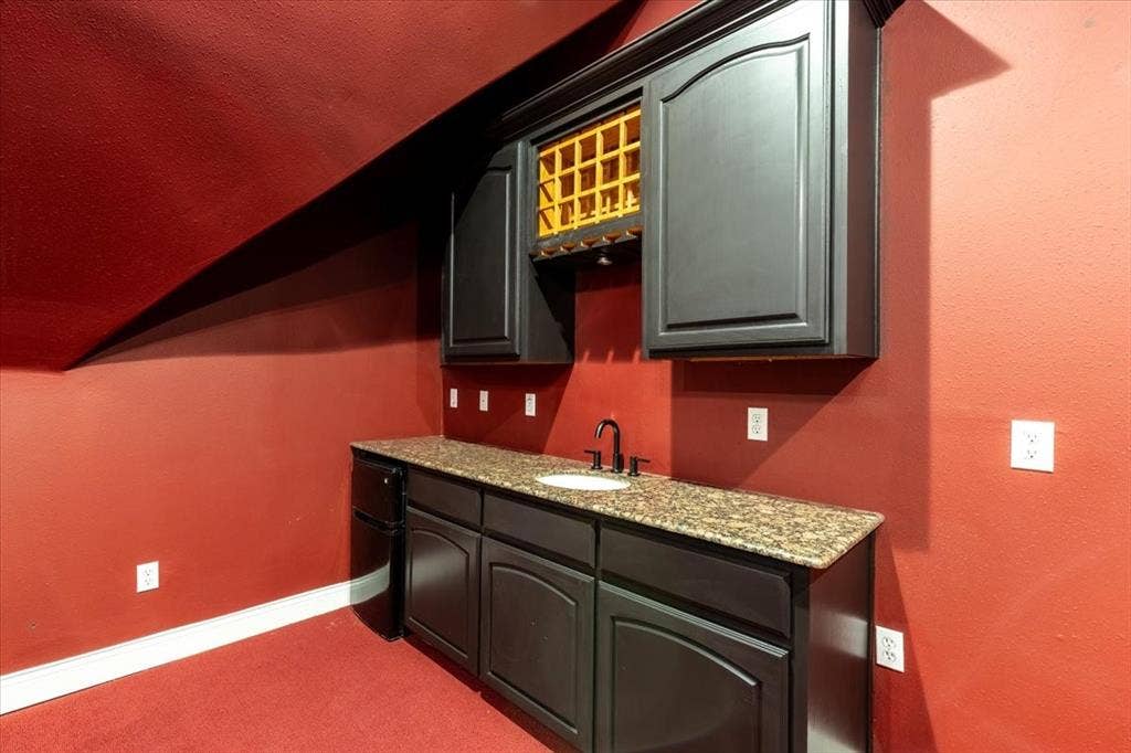 5182 Bayshore Drive, Athens, TX 75752 Indoor wet bar with light stone counters, dark carpet, and lofted ceiling