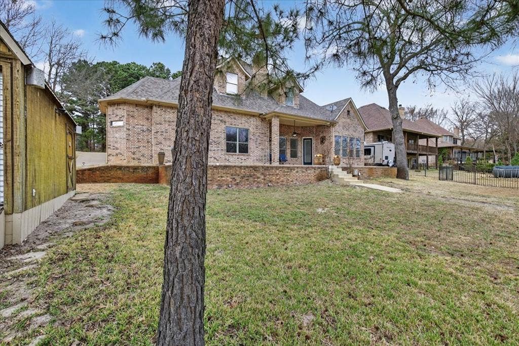 5182 Bayshore Drive, Athens, TX 75752 Back of house featuring brick siding, a patio, and a shingled roof