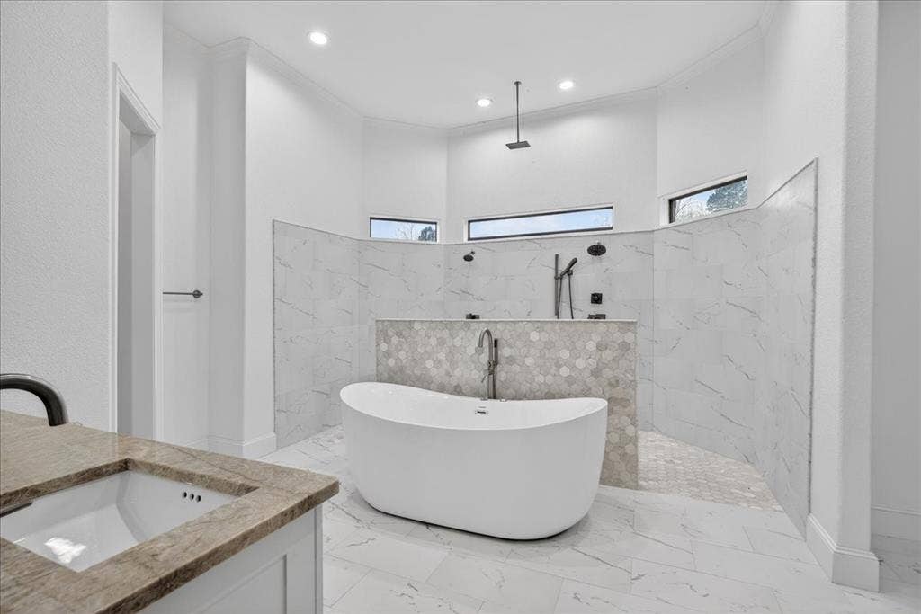 5182 Bayshore Drive, Athens, TX 75752 Bathroom featuring a marble finish shower, a freestanding bath, vanity, light marble finish flooring, and recessed lighting