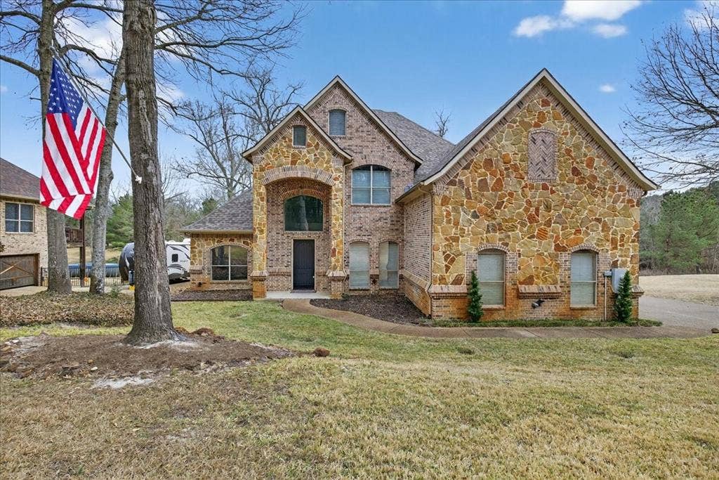 5182 Bayshore Drive, Athens, TX 75752 French country home with brick siding, stone siding, and a front lawn