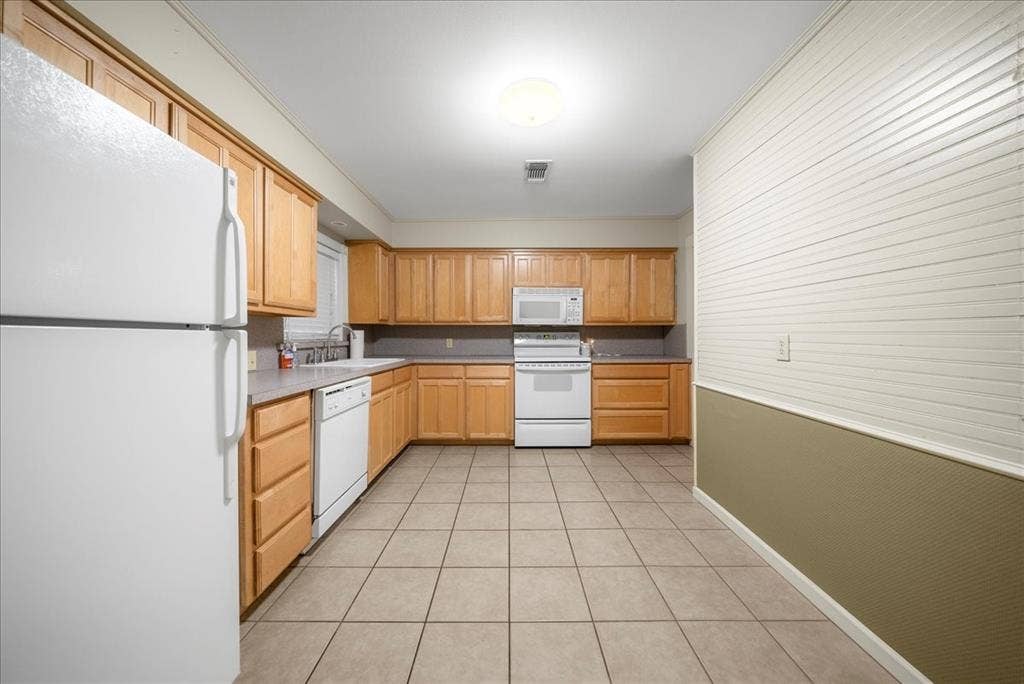 101 N 7th Street, Krum, TX 76249 Kitchen featuring white appliances, light tile patterned floors, light countertops, and light brown cabinets