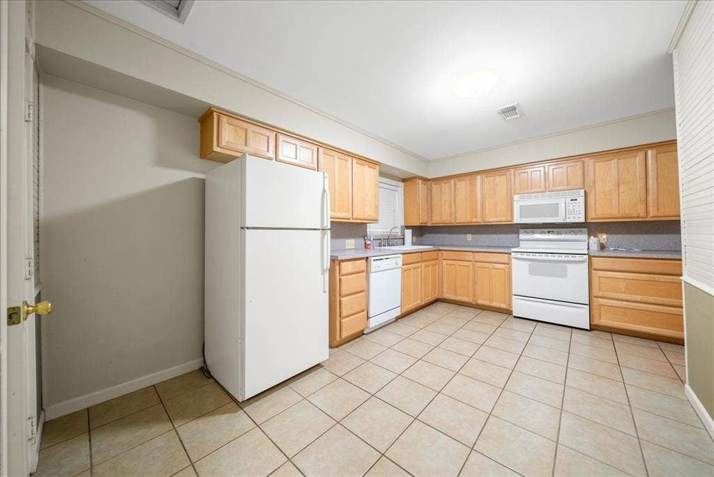 101 N 7th Street, Krum, TX 76249 Kitchen with light brown cabinets, white appliances, light countertops, and light tile patterned flooring