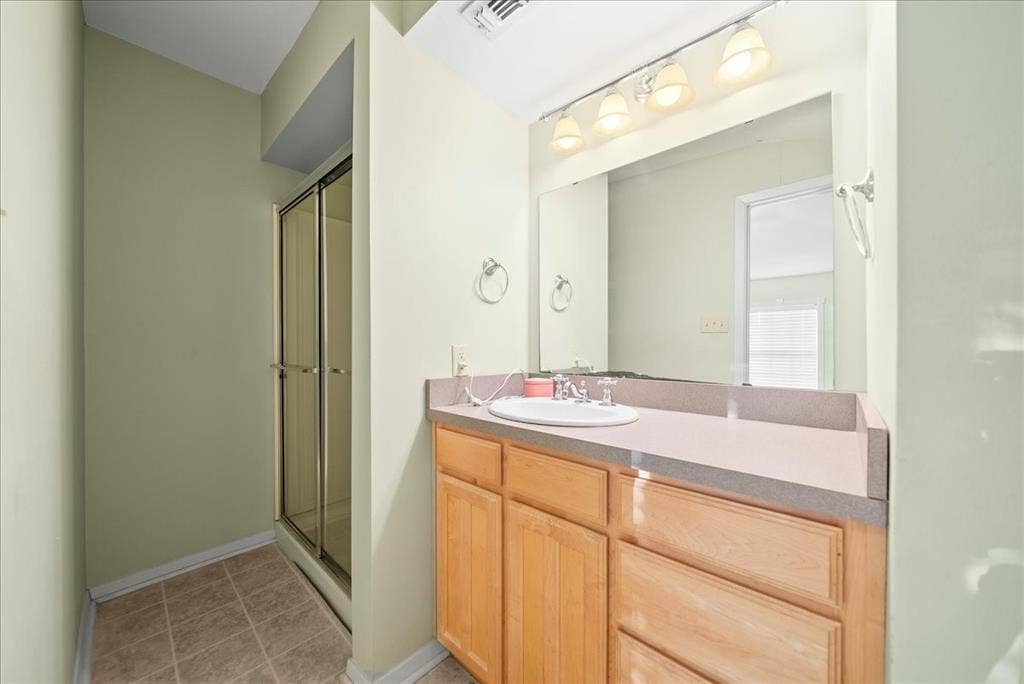 101 N 7th Street, Krum, TX 76249 Full bath featuring vanity, a stall shower, and light tile patterned floors