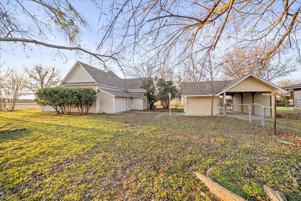 101 N 7th Street, Krum, TX 76249 View of yard featuring an attached garage, a carport, and a patio area