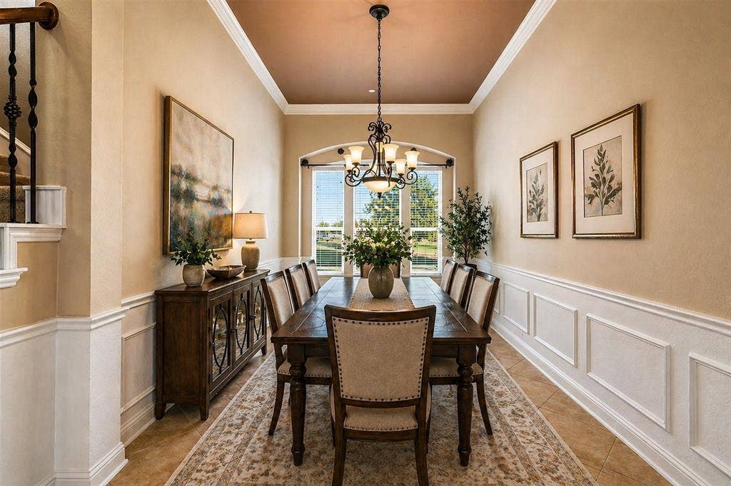 Virtually Staged Recessed tray ceiling with crown molding and chandelier, framed by arched window with exterior views