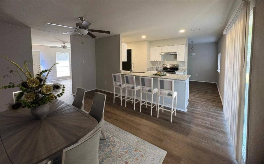 117 Yorkshire Drive, Cedar Hill, TX 75104 Dining space open to kitchen seperated by a large island dark wood finished floors, recessed lighting, and a ceiling fan, Virtual staging