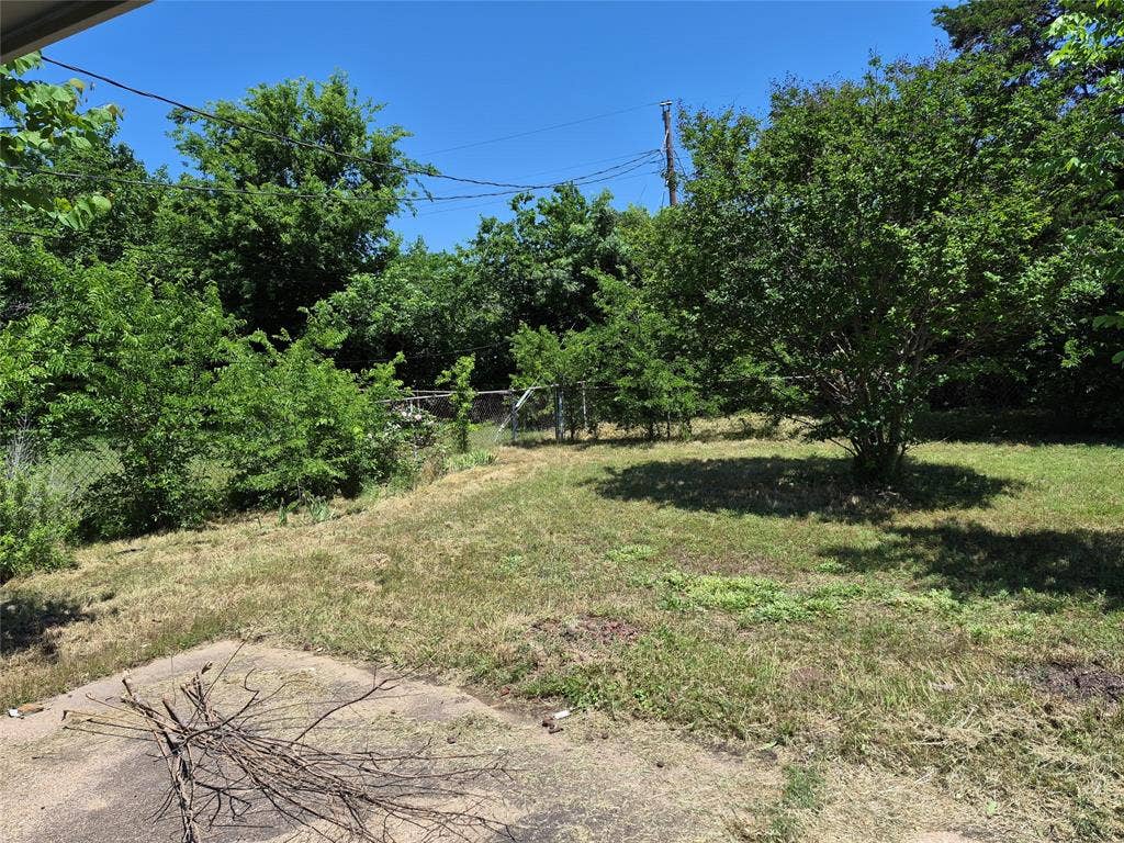 117 Yorkshire Drive, Cedar Hill, TX 75104 Expansive backyard with a sloped grade, featuring a mature tree and established shrubbery
