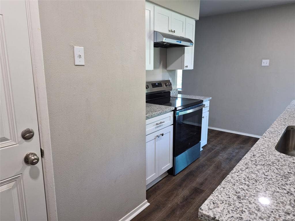 117 Yorkshire Drive, Cedar Hill, TX 75104 Kitchen featuring granite countertops, white cabinetry with dark pulls, stainless steel appliances, and wood-finish flooring