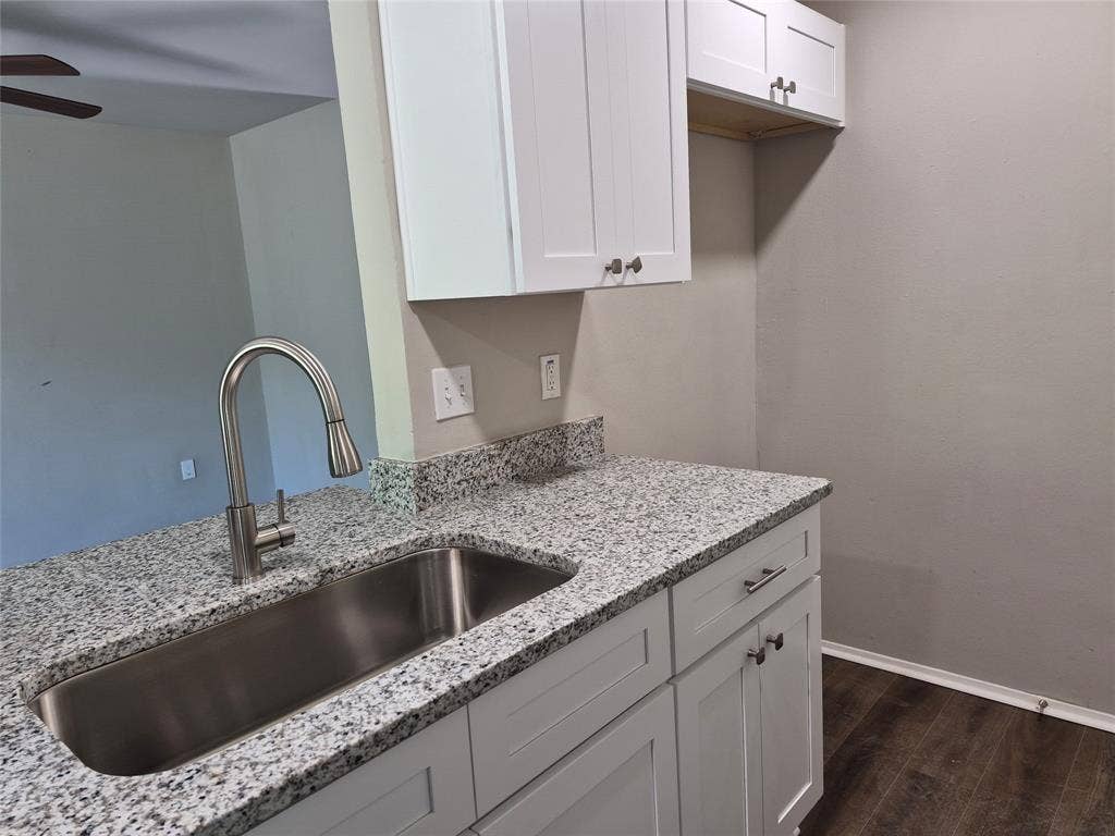 117 Yorkshire Drive, Cedar Hill, TX 75104 Kitchen with granite countertops, stainless steel sink, gooseneck faucet, white shaker-style cabinetry, and wood-finish flooring