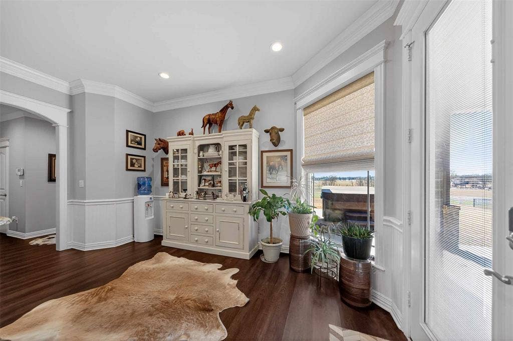 23151 Champion Drive, Lindale, TX 75771 Living area featuring crown molding, wainscoting, dark wood-style flooring, arched walkways, and recessed lighting