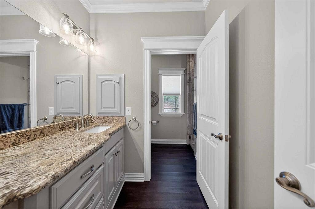 23151 Champion Drive, Lindale, TX 75771 Bathroom with vanity, crown molding, and dark wood finished floors