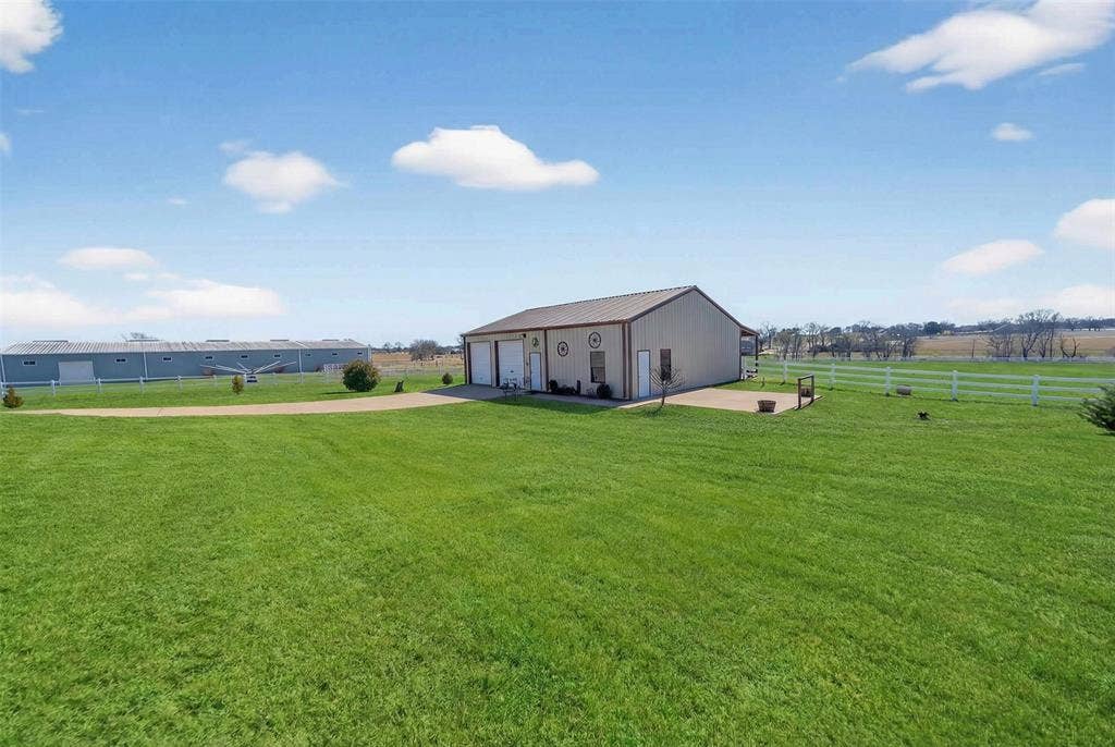 23151 Champion Drive, Lindale, TX 75771 View of yard with an outdoor structure, a detached garage, and a view of rural / pastoral area