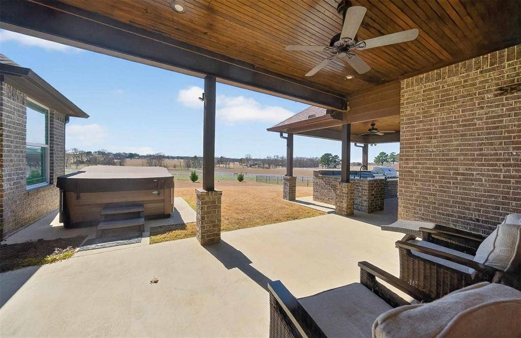 23151 Champion Drive, Lindale, TX 75771 View of patio / terrace featuring ceiling fan, a hot tub, and an outdoor kitchen