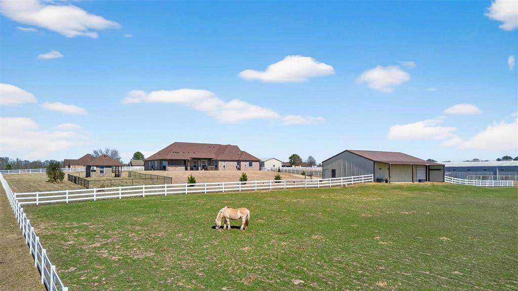 23151 Champion Drive, Lindale, TX 75771 View of yard with an enclosed riding area, an outbuilding, and a view of countryside