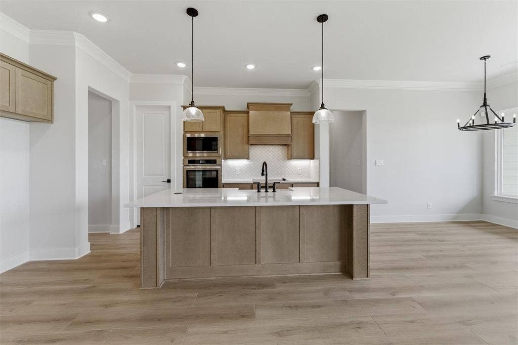 2204 Continent Court, Krum, TX 76249 Kitchen featuring a large central island with a light-toned countertop, wood-finish flooring, recessed lighting, and pendant fixtures