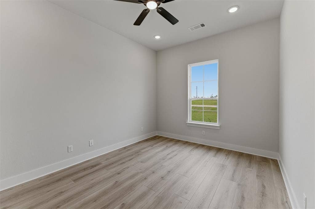 2204 Continent Court, Krum, TX 76249 Bright interior space featuring a window with exterior views, wood-finish flooring, a ceiling fan, and recessed lighting