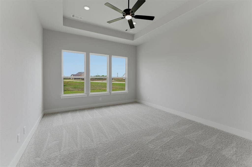2204 Continent Court, Krum, TX 76249 Spacious room featuring a tray ceiling with recessed lighting and a ceiling fan