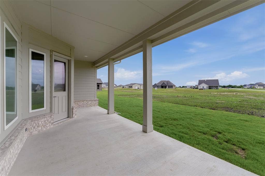 2204 Continent Court, Krum, TX 76249 Covered concrete patio with recessed lighting, stone veneer accents, multiple windows, and a glass-paneled door