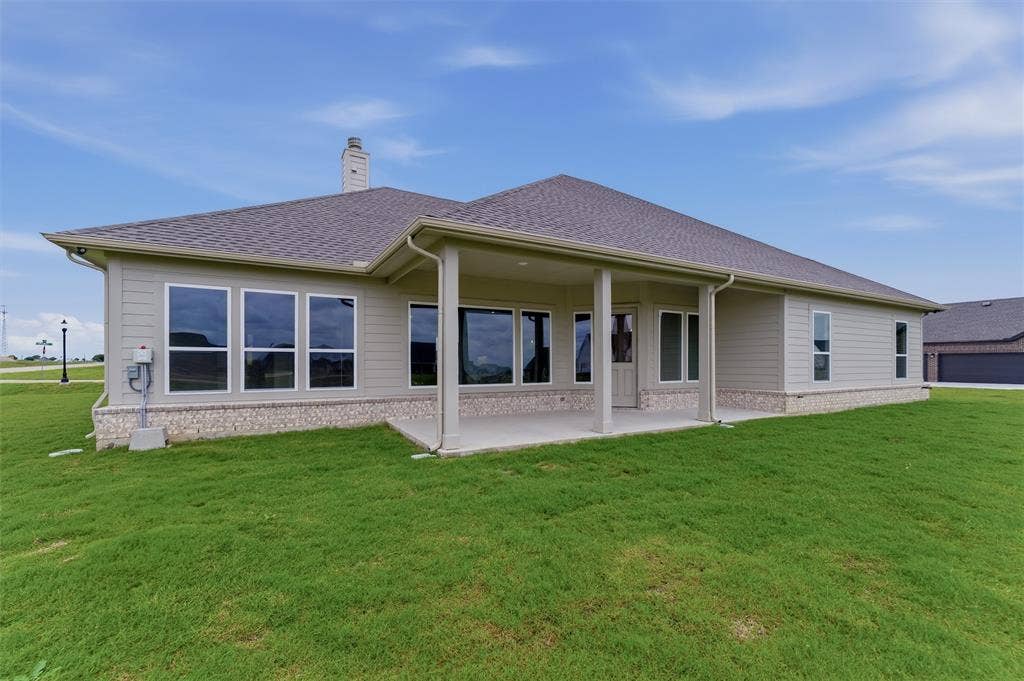 2204 Continent Court, Krum, TX 76249 Rear elevation featuring a covered patio with columns, multiple large windows, and a chimney