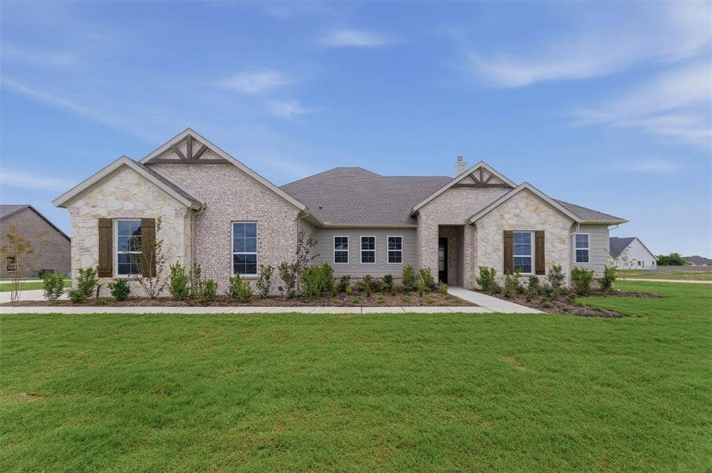 2204 Continent Court, Krum, TX 76249 Single-story residence featuring a mixed-material facade of light-colored stone and brick