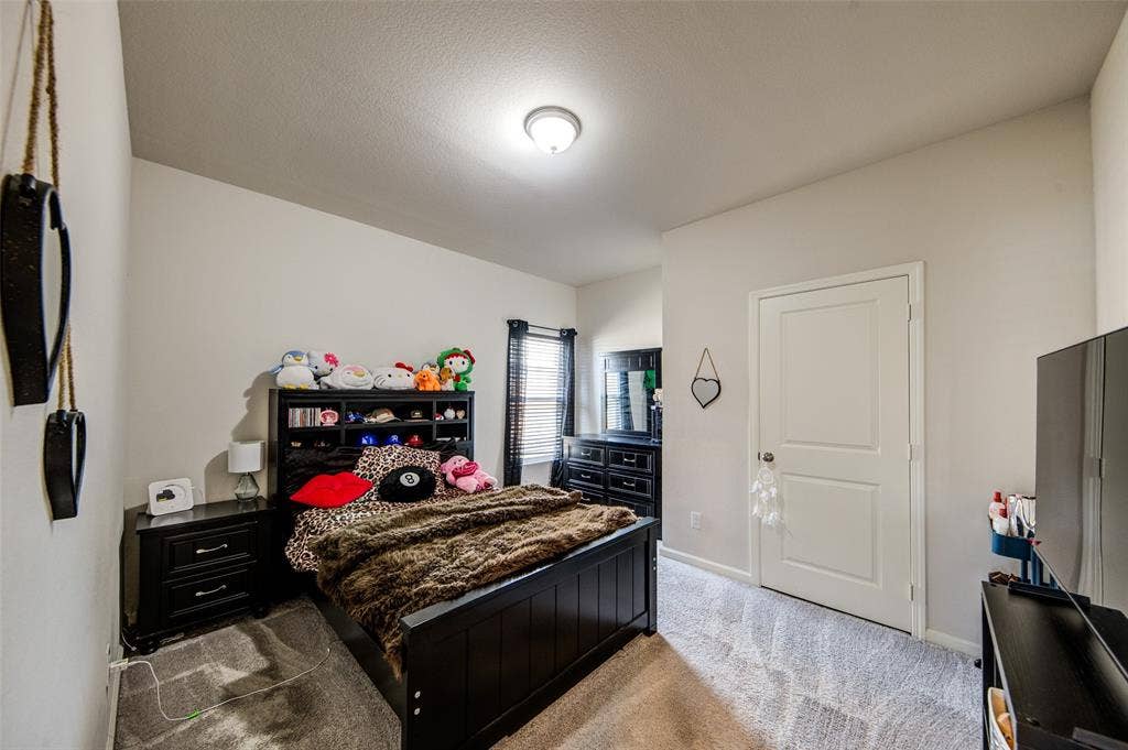 Bedroom featuring light carpet and baseboards
