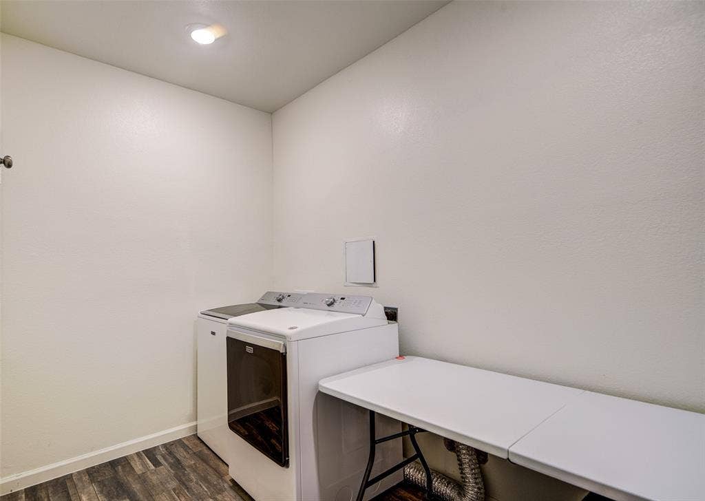 Laundry area featuring dark wood-style floors and separate washer and dryer