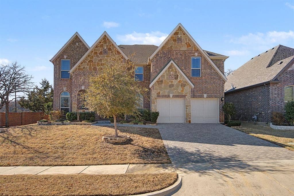 3409 Florence Drive, Corinth, TX 76210 View of front of house featuring brick siding, driveway, stone siding, and attached garage