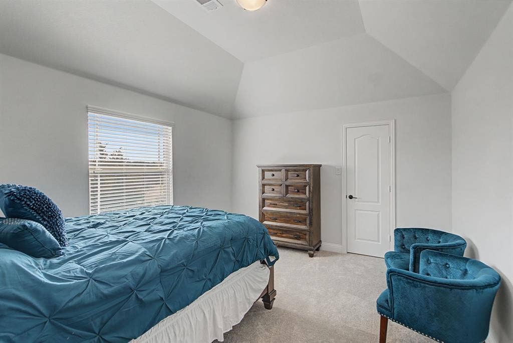 3409 Florence Drive, Corinth, TX 76210 Carpeted bedroom featuring vaulted ceiling and baseboards