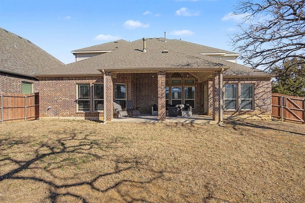 3409 Florence Drive, Corinth, TX 76210 Rear view of house with a gate, roof with shingles, a fenced backyard, and a patio area