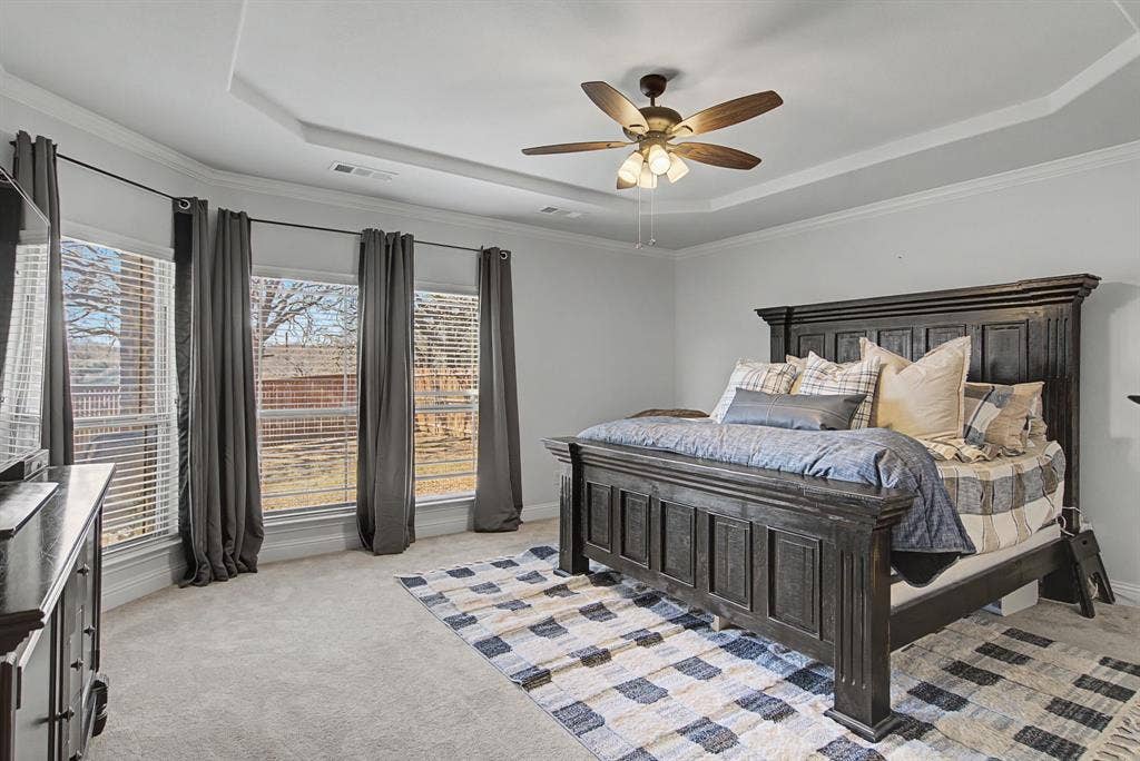 3409 Florence Drive, Corinth, TX 76210 Bedroom featuring a raised ceiling, light carpet, a ceiling fan, and ornamental molding