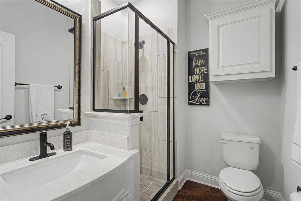 3409 Florence Drive, Corinth, TX 76210 Bathroom with a stall shower, vanity, and dark wood-type flooring