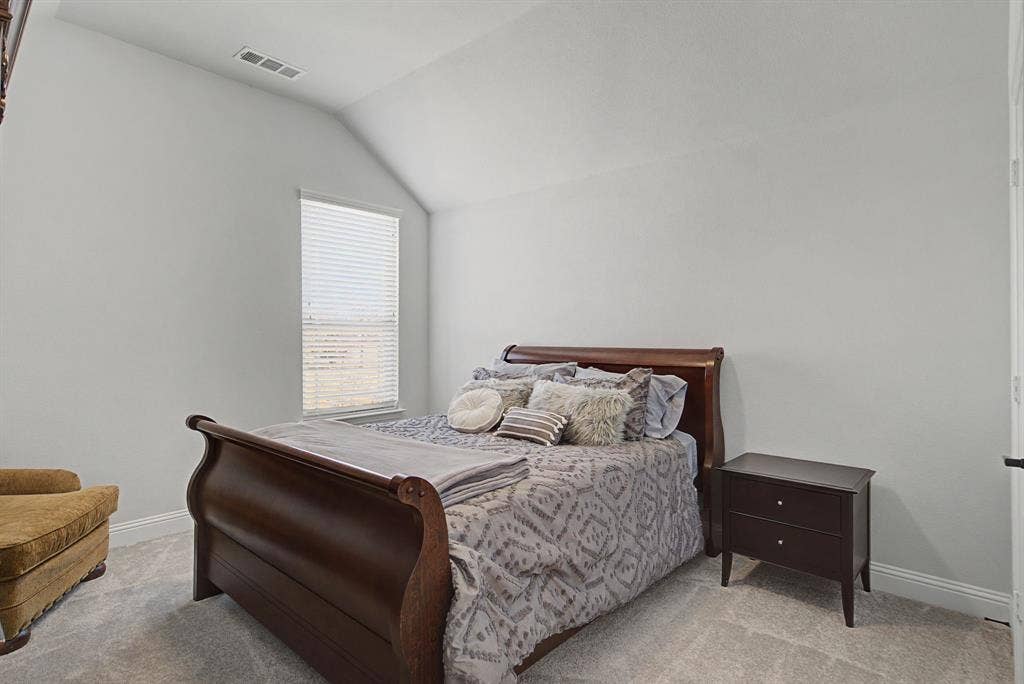 3409 Florence Drive, Corinth, TX 76210 Carpeted bedroom with baseboards and vaulted ceiling