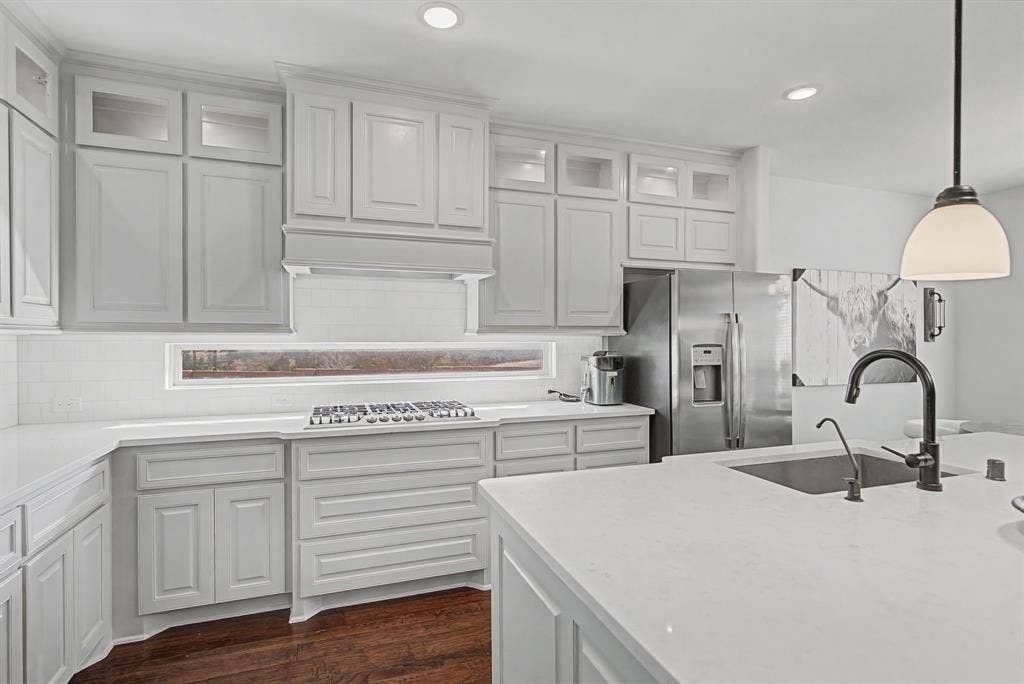 3409 Florence Drive, Corinth, TX 76210 Kitchen featuring decorative light fixtures, stainless steel appliances, decorative backsplash, glass insert cabinets, and light stone counters
