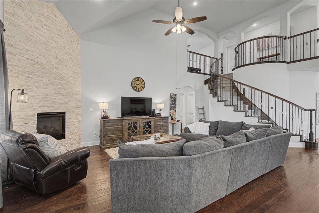 3409 Florence Drive, Corinth, TX 76210 Living area featuring arched walkways, dark wood-style floors, ceiling fan, a stone fireplace, and recessed lighting