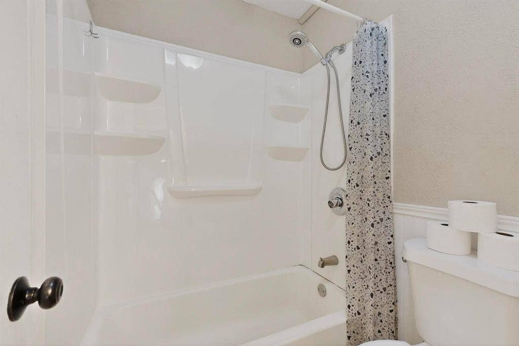 2315 Blue Sage Lane, Arlington, TX 76014 Bathroom featuring a wainscoted wall and shower / tub combination