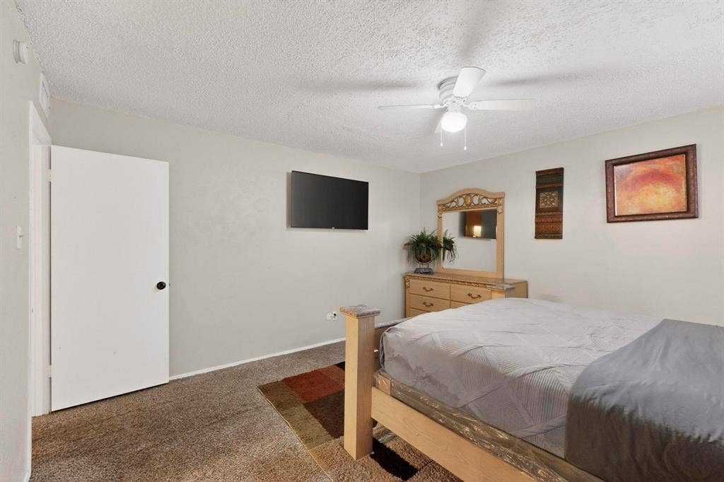 2315 Blue Sage Lane, Arlington, TX 76014 Bedroom featuring carpet floors, a textured ceiling, and a ceiling fan