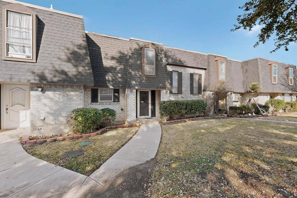 2315 Blue Sage Lane, Arlington, TX 76014 View of front of house with mansard roof, brick siding, a shingled roof, and a front lawn