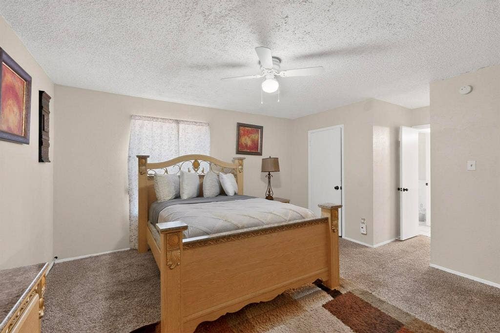 2315 Blue Sage Lane, Arlington, TX 76014 Bedroom featuring a textured ceiling, a ceiling fan, and light colored carpet