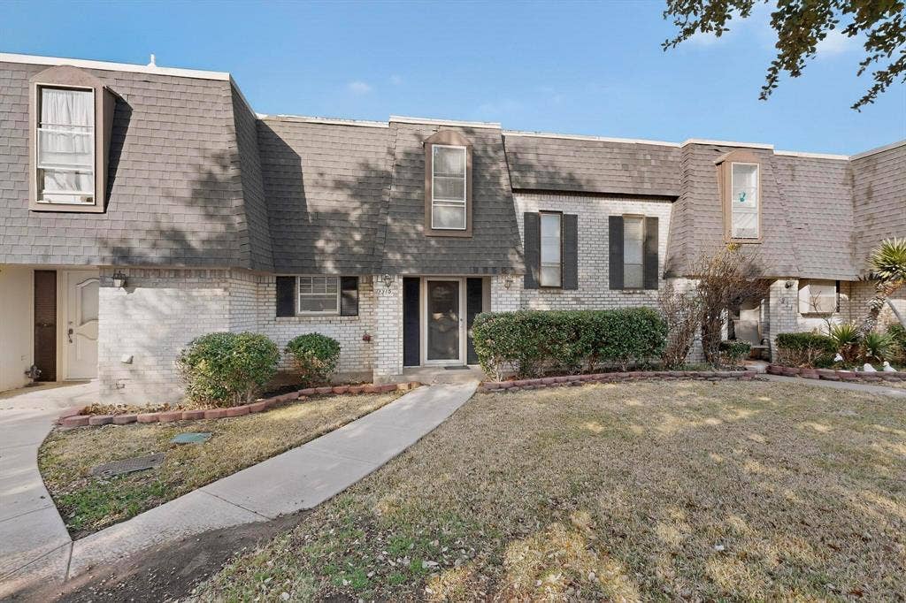 2315 Blue Sage Lane, Arlington, TX 76014 View of front of house with mansard roof, brick siding, roof with shingles, and a front lawn