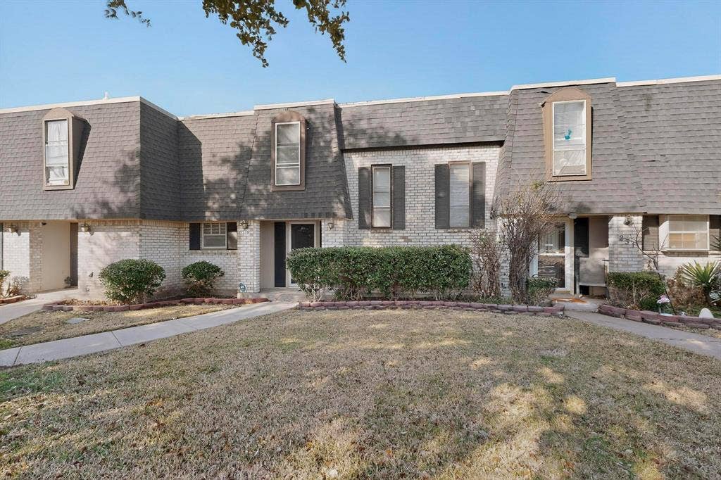 2315 Blue Sage Lane, Arlington, TX 76014 View of front facade featuring mansard roof, brick siding, a shingled roof, and a front yard