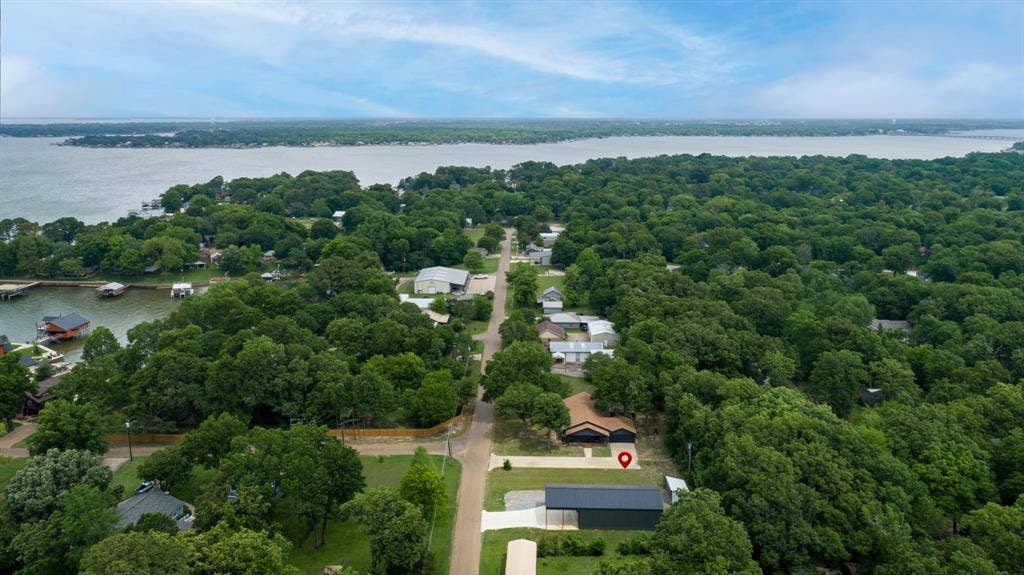 129 King Arthur Road, Mabank, TX 75156 Aerial view showcasing the property's proximity to a large body of water, surrounded by lush green trees