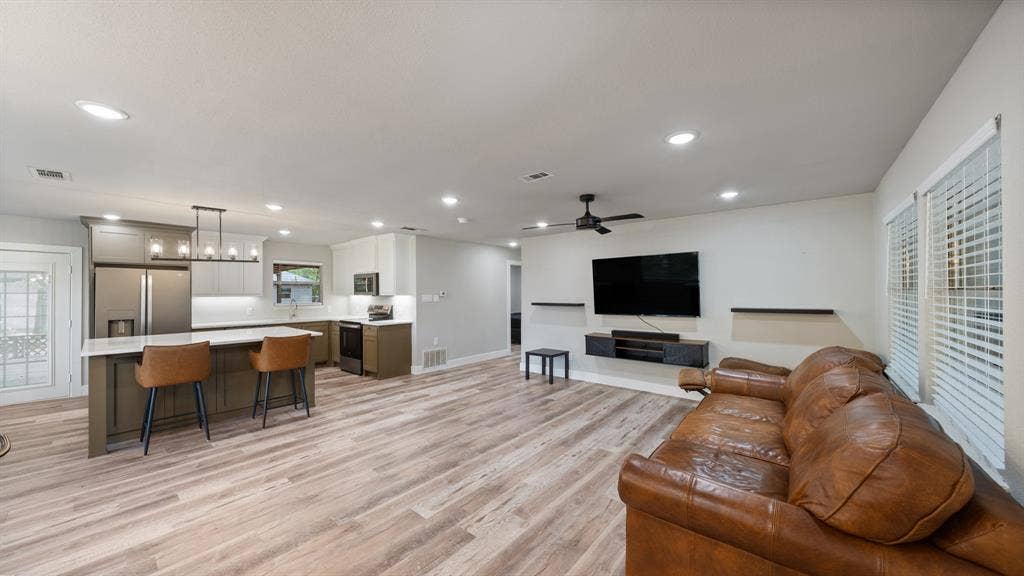 129 King Arthur Road, Mabank, TX 75156 The open concept living area features recessed lighting, light-toned flooring, and windows with blinds, providing natural light