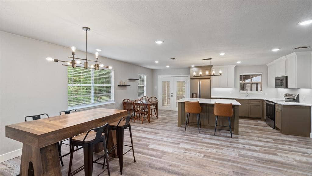 129 King Arthur Road, Mabank, TX 75156 Spacious open-concept living area featuring light-toned flooring, recessed lighting, and a modern kitchen with a central island