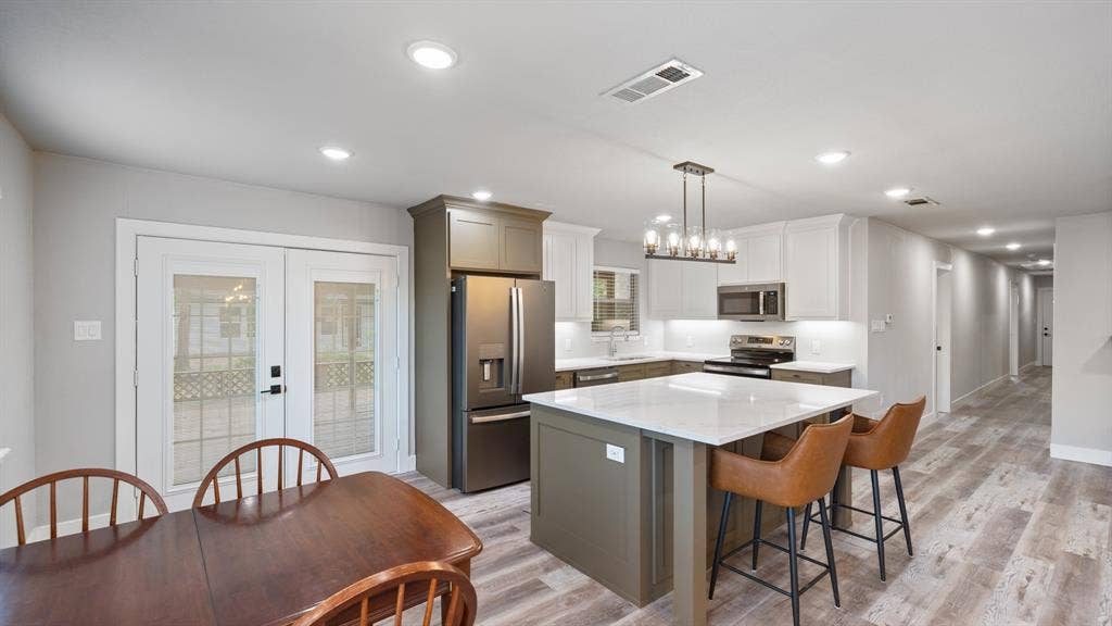 129 King Arthur Road, Mabank, TX 75156 The property features an open-plan kitchen and dining area with modern appliances and light-colored flooring