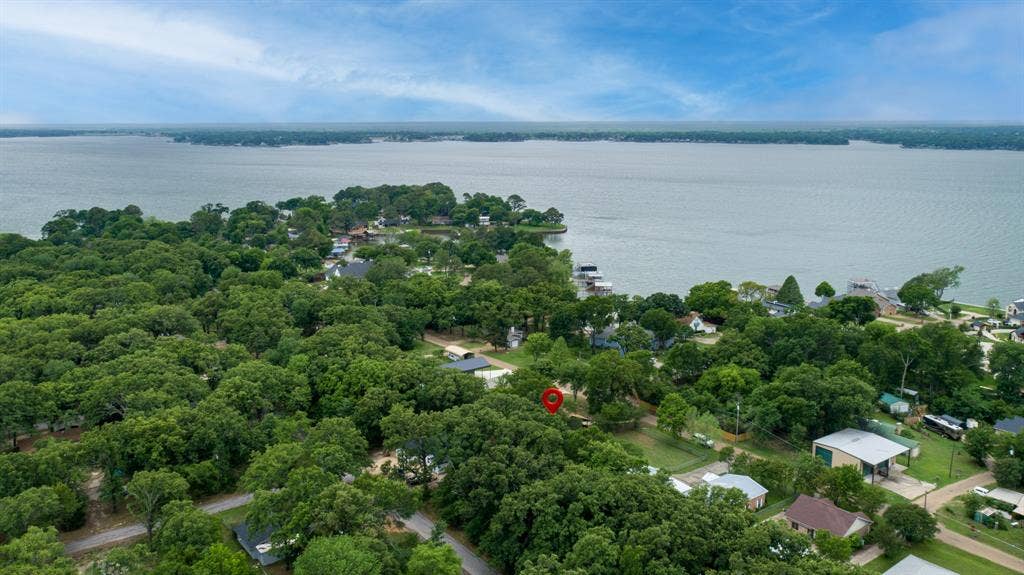 129 King Arthur Road, Mabank, TX 75156 This property is located in a community with extensive tree coverage and features a prominent lake view