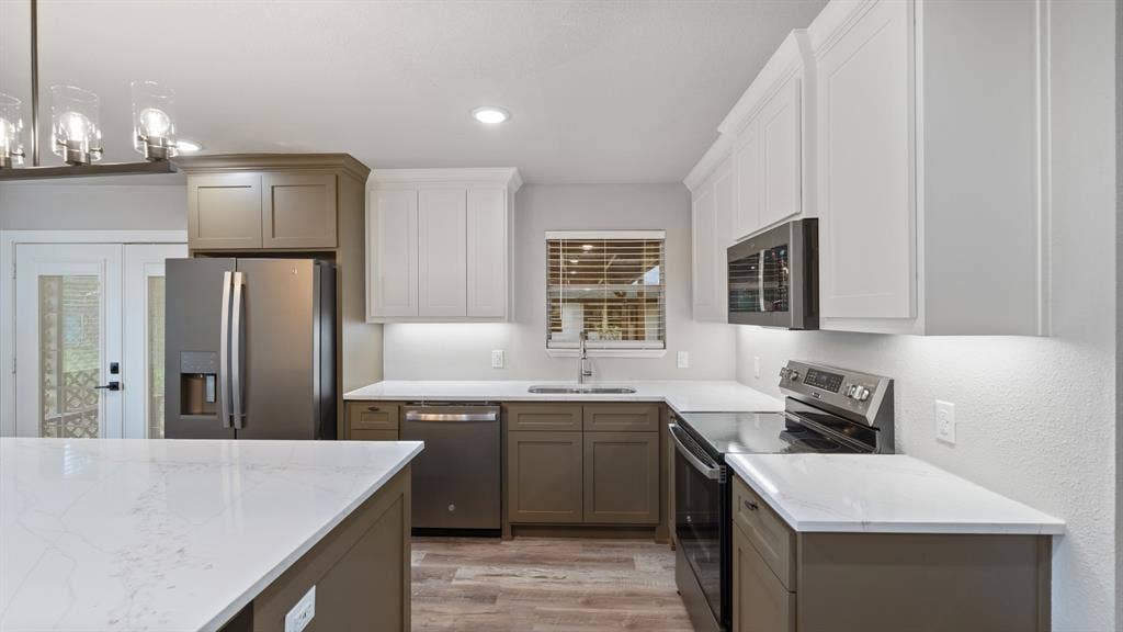 129 King Arthur Road, Mabank, TX 75156 Modern kitchen featuring white and grey cabinetry, stainless steel appliances, white countertops, and wood-style flooring