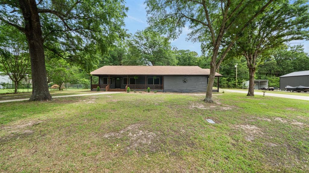 129 King Arthur Road, Mabank, TX 75156 The property features a ranch-style exterior with a covered front porch and a brown roof