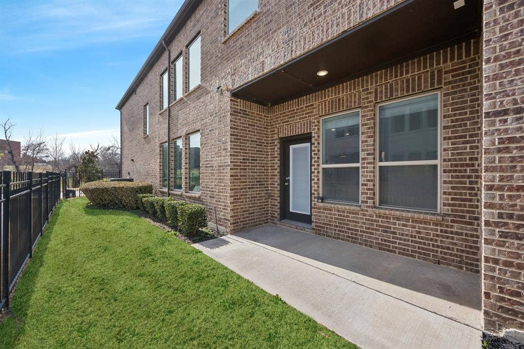 648 Courtyard Lane, Irving, TX 75039 Property entrance with brick siding and a patio area